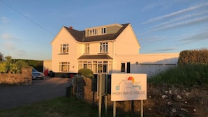 A two-story house with a garage, a driveway, and a sign indicating it is a B&B named 'HIGH WAYS HOUSE'. - High Ways House (Ilfracombe)