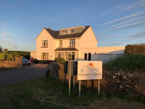 A two-story house with a garage, a driveway, and a sign indicating it is a B&B named 'HIGH WAYS HOUSE'. - High Ways House (Ilfracombe)