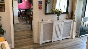 A hallway with a radiator, a mirror, and a door leading to another room. - High Ways House (Ilfracombe)