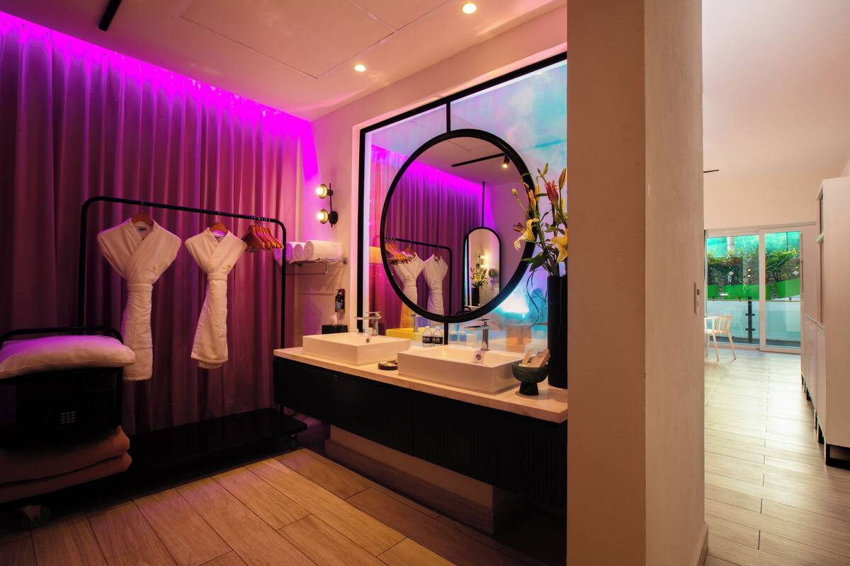 Un baño moderno con dos lavamanos, un espejo grande y una zona de tocador.