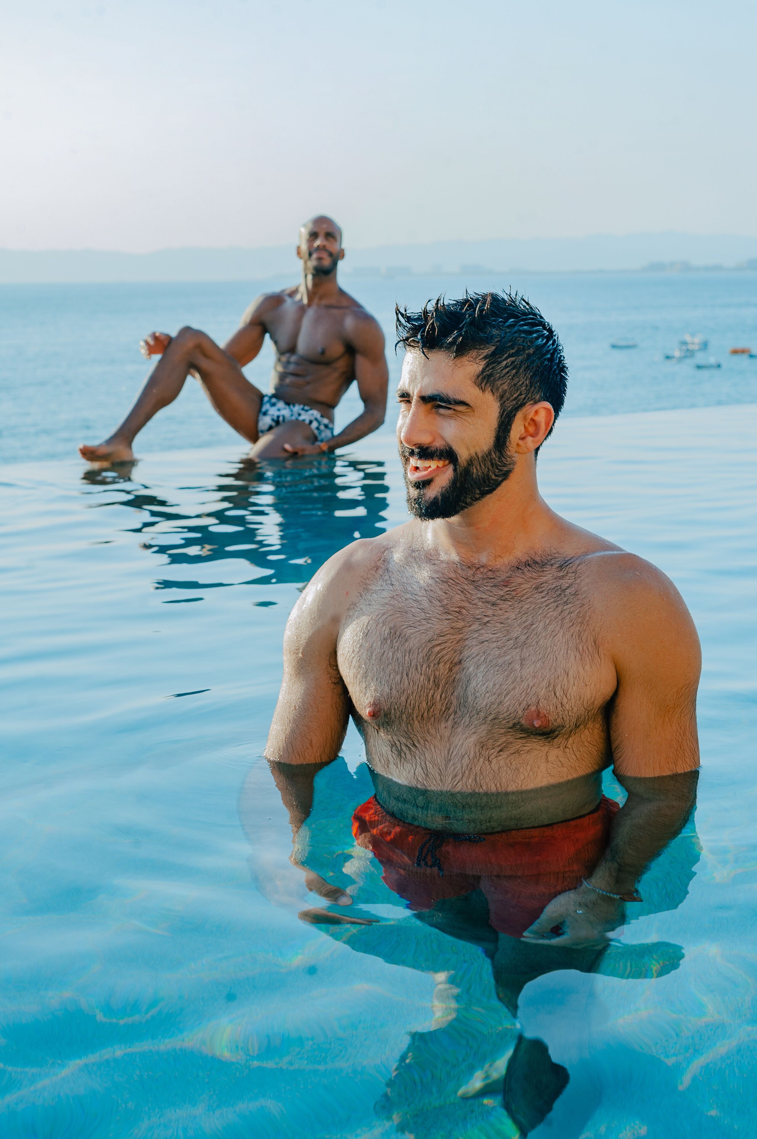 Un homme dans une piscine, avec une vue dégagée sur l’eau et un horizon lointain.