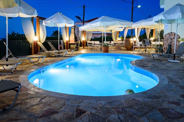 Una piscina al aire libre, tumbonas