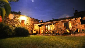 A stone building with a patio area featuring outdoor seating. - La Trocha de Hoyorredondo (Hoyorredondo)