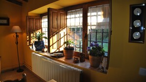 A room with a window sill adorned with potted plants and a radiator. - La Trocha de Hoyorredondo (Hoyorredondo)