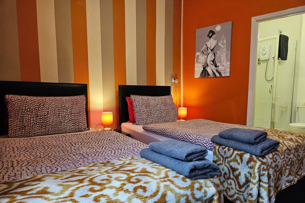 Phòng 2 giường đơn Deluxe, có phòng tắm riêng (Orange Room) | Bàn, khu vực làm việc phù hợp cho laptop, màn/rèm cản sáng 
