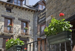 A stone building with balconies and flower boxes.