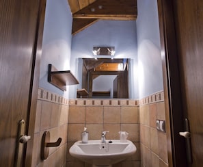 A bathroom with a sink, mirror, and wooden ceiling. - Borda Felices - Hostel (Broto)