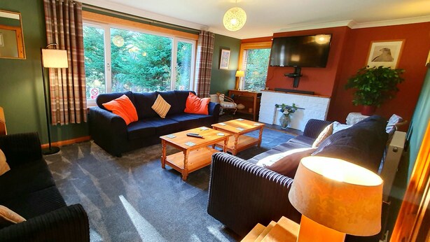 A living room with a sofa, armchairs, a coffee table, and a TV. - Torcroft Lodges (Inverness)