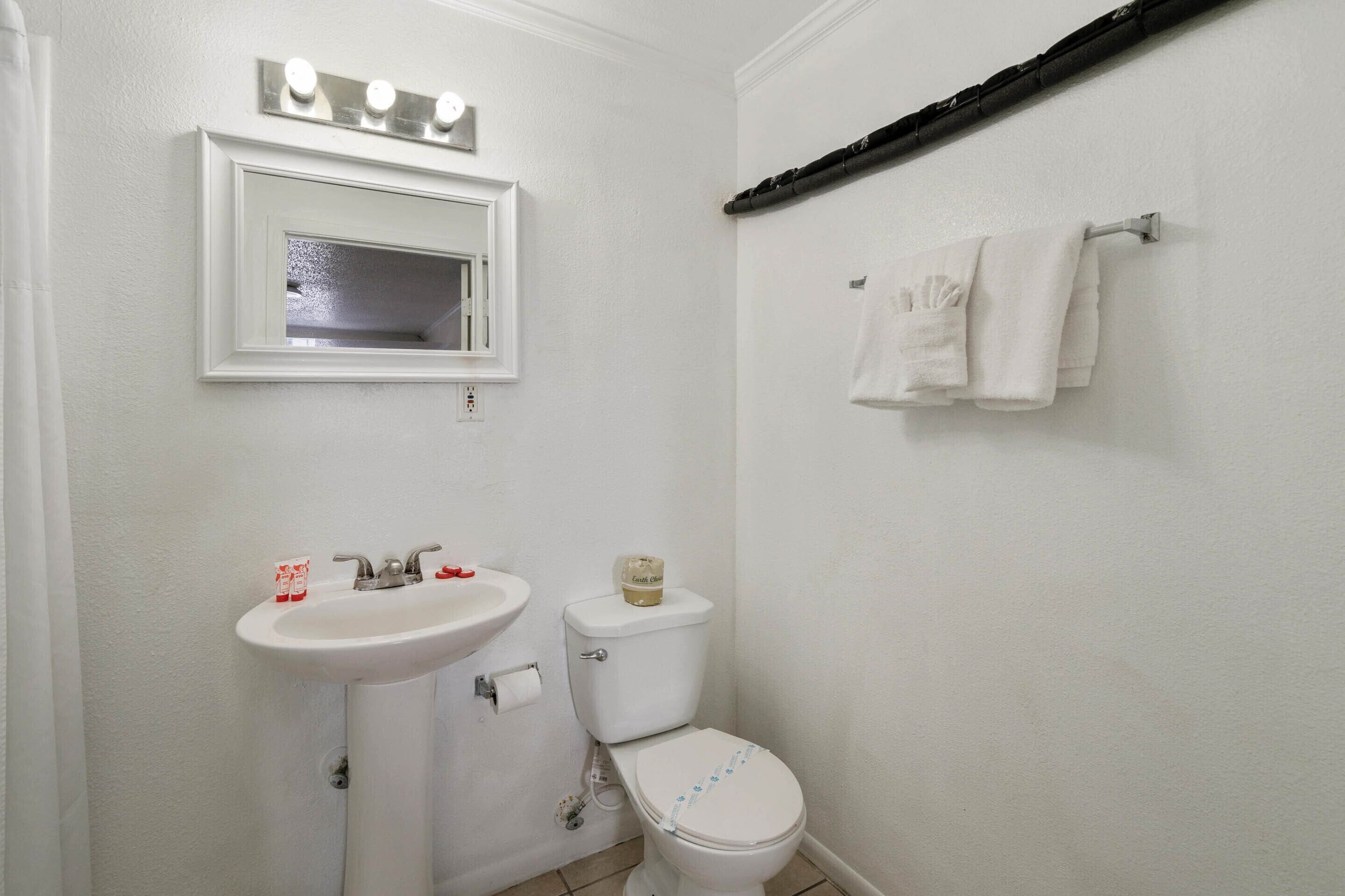 A bathroom with a sink, mirror, and toilet.