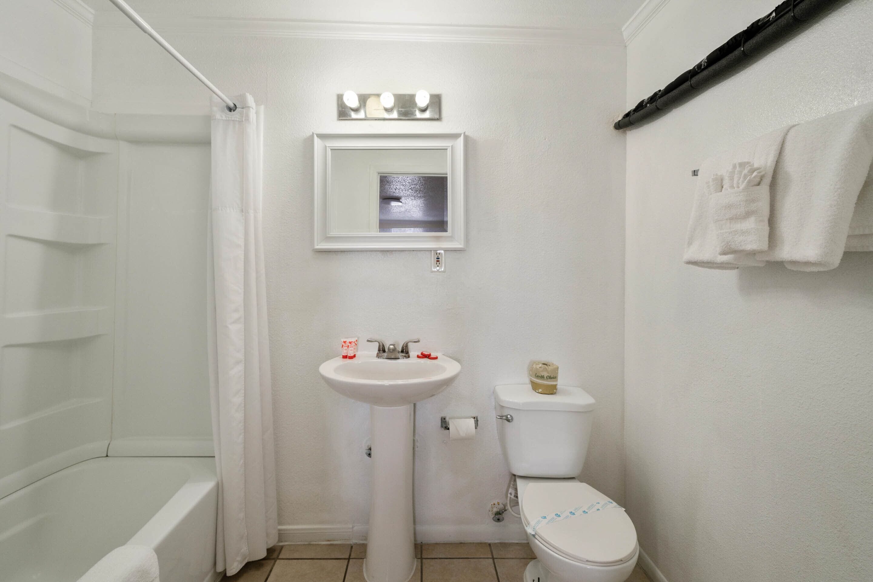 Une salle de bain équipée d’une baignoire, d’un lavabo, de toilettes et d’un porte-serviettes.