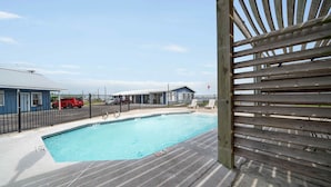 Una piscina con muelle de madera y cerca.
