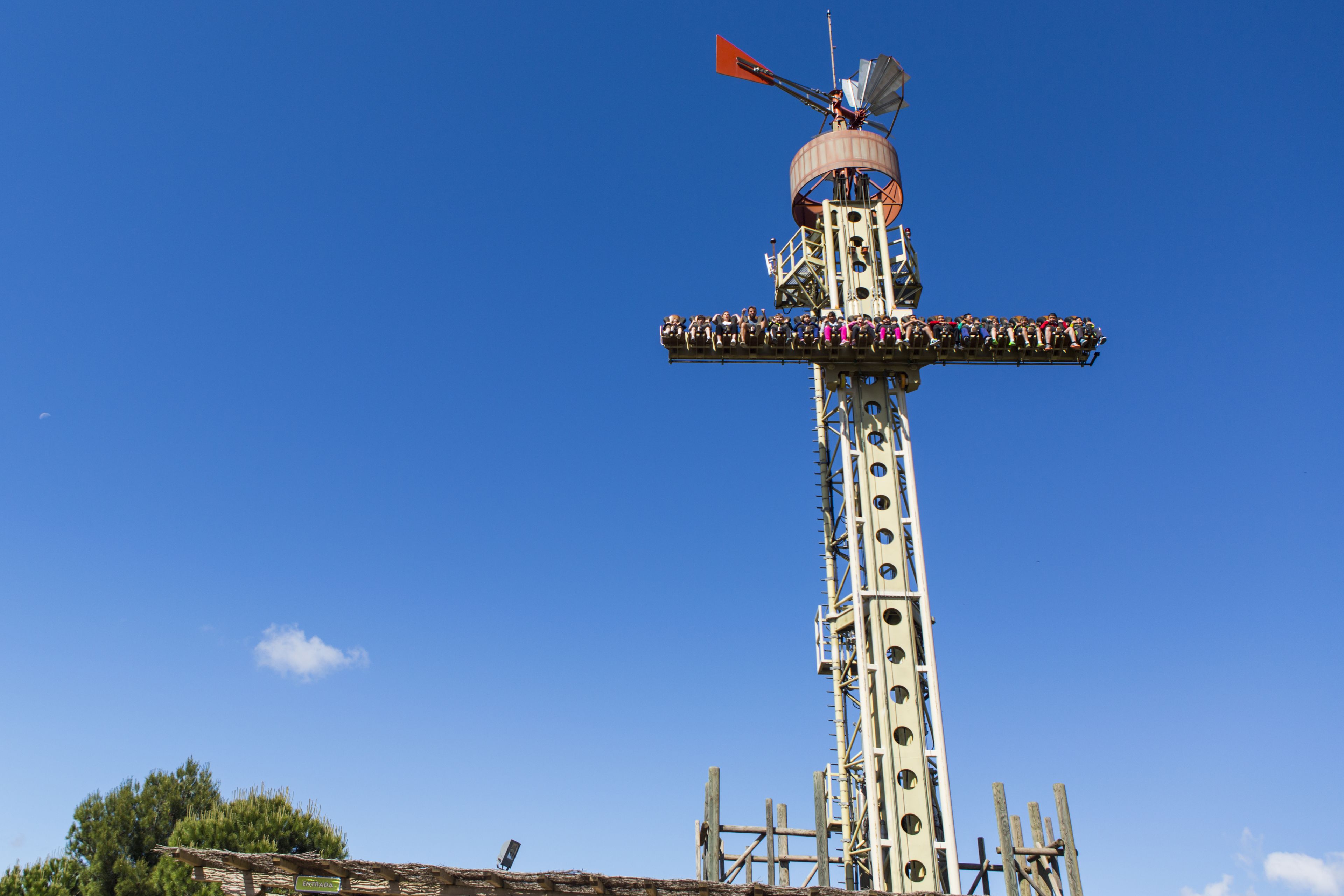 Una torre alta con un molino de viento en la parte superior, rodeada por una multitud.