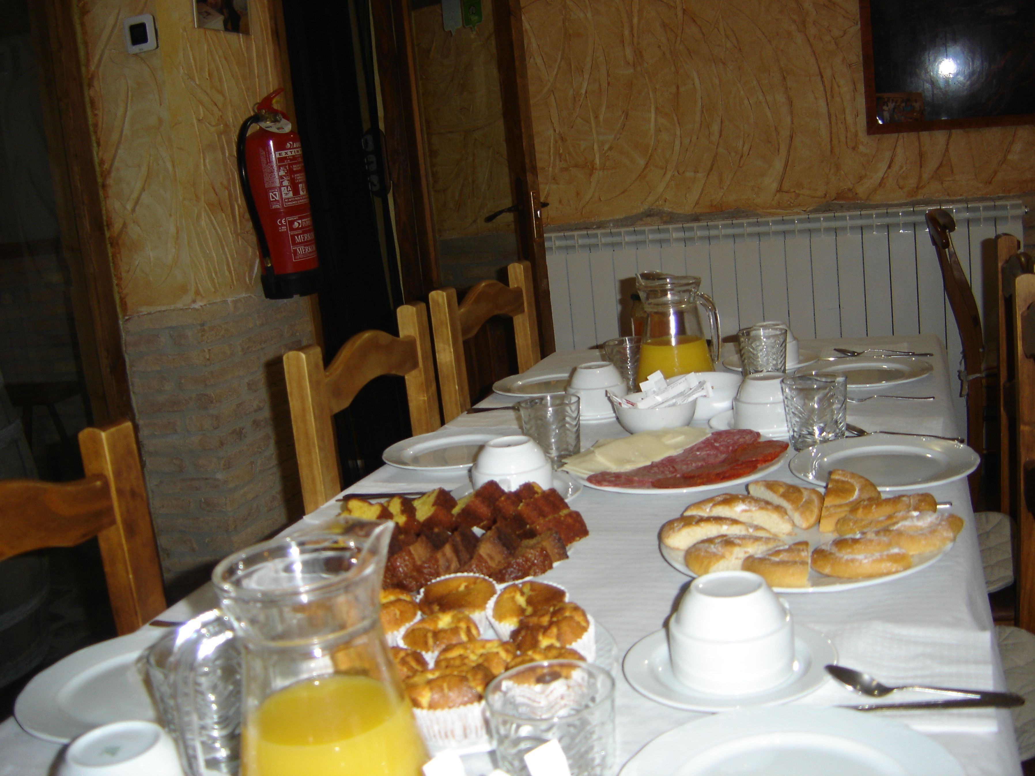 Een ontbijttafel gedekt met borden, glazen en diverse soorten eten.