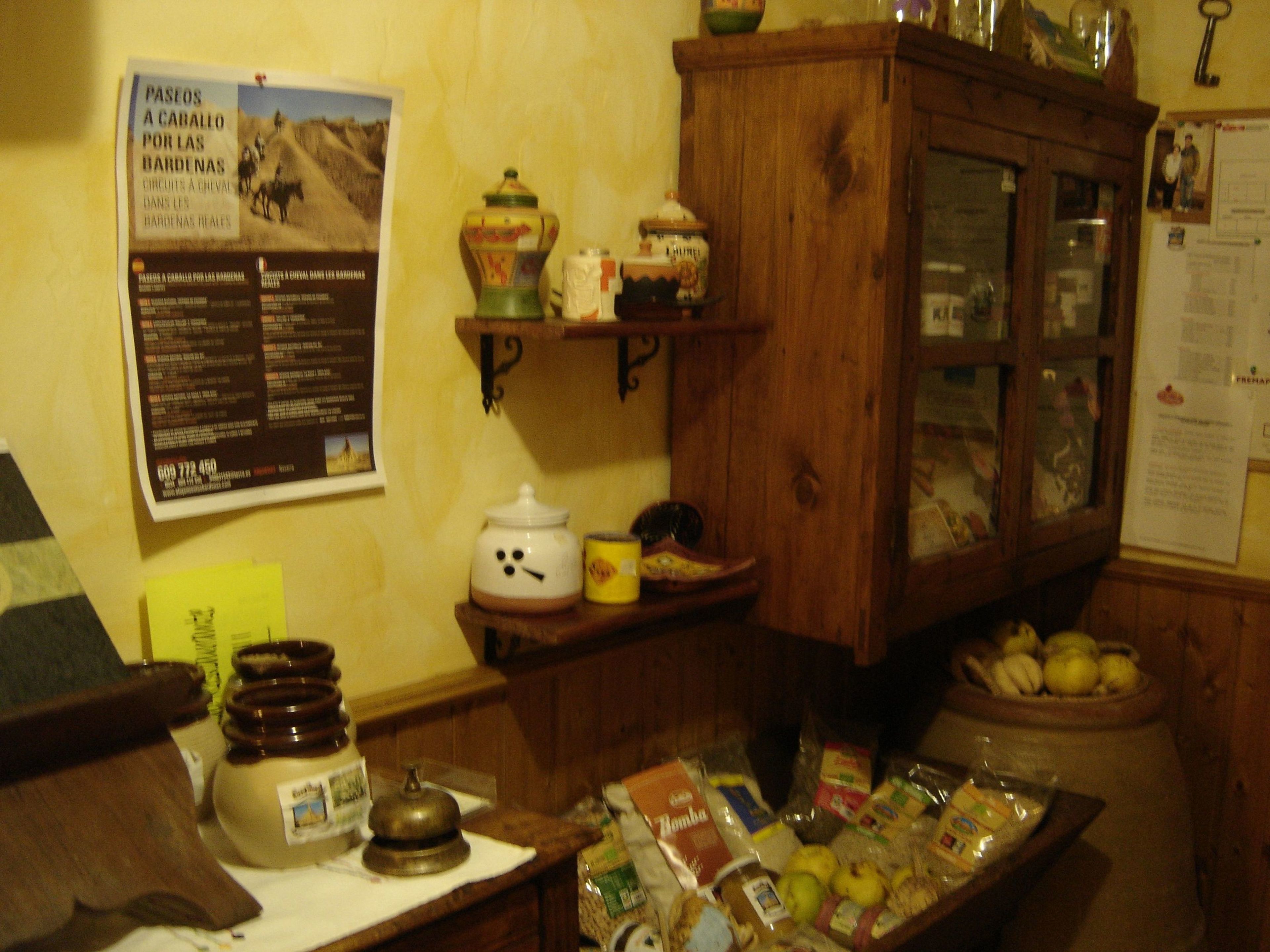 A kitchen with a wooden cabinet, a poster on the wall, and various kitchen items on the counter.
