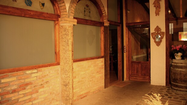 A hallway with brick walls, wooden door frames, and a wooden staircase. - Casa rural La Bardena Blanca I (Arguedas)