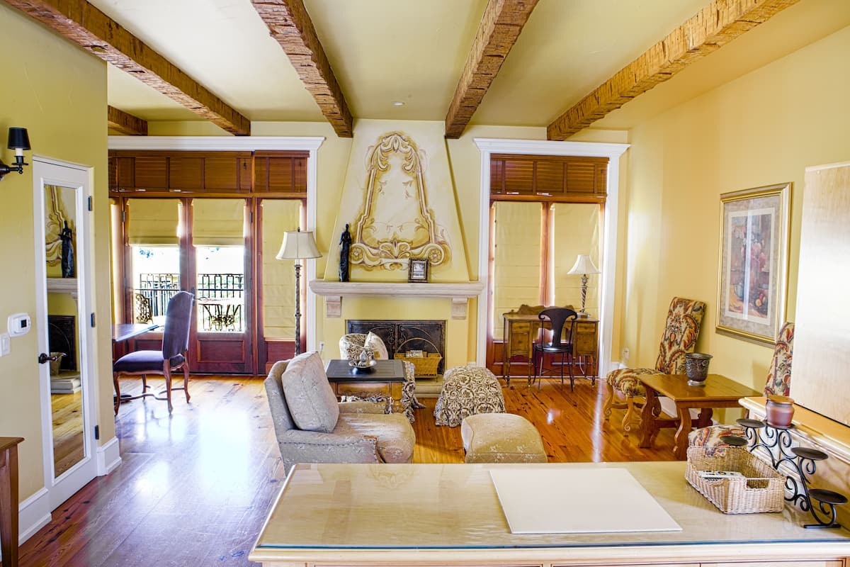 Un salon spacieux doté de parquets en bois, d’une cheminée et d’un coin repas avec des meubles en bois.