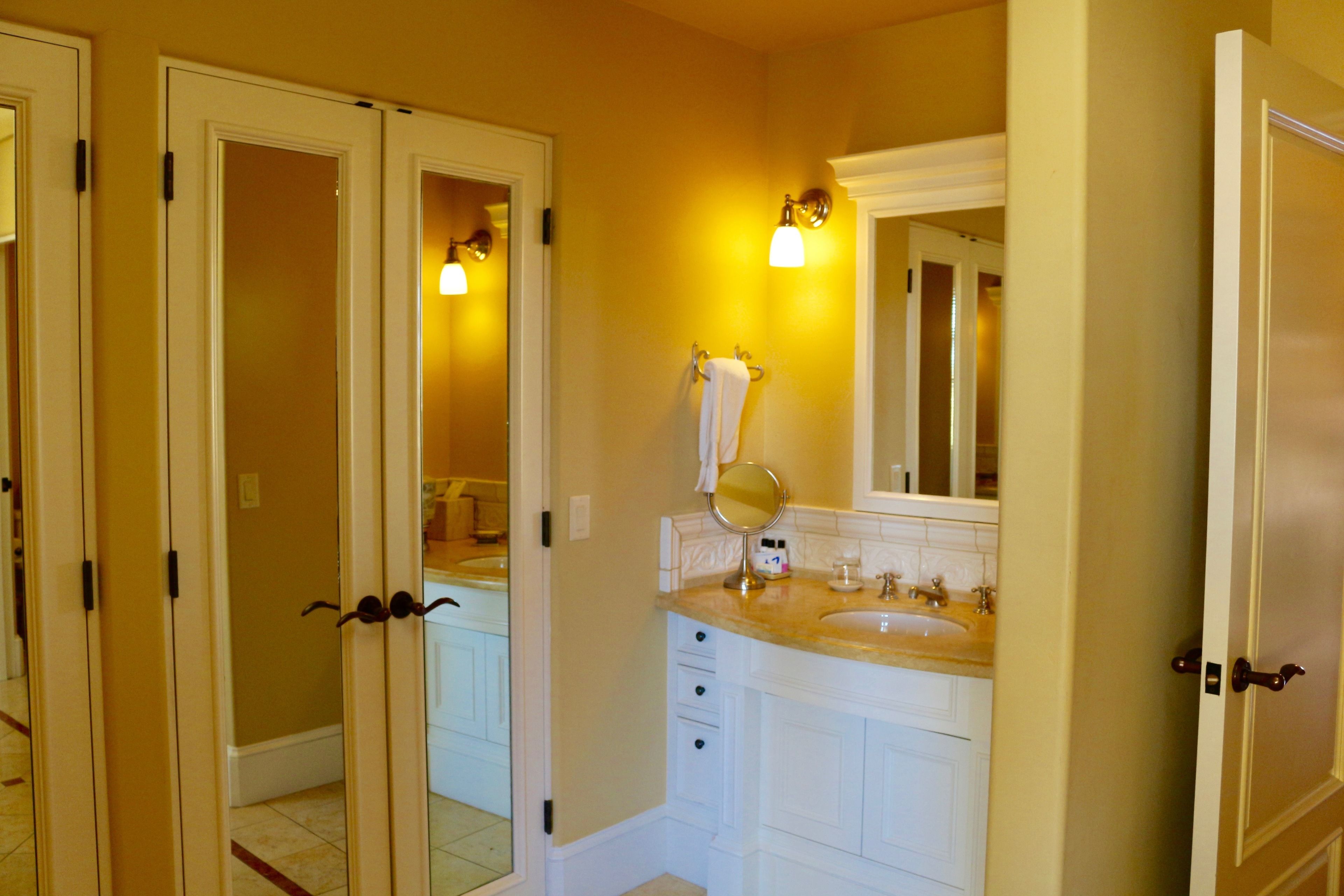 A bathroom with a double sink vanity, a mirror, and a towel rack.