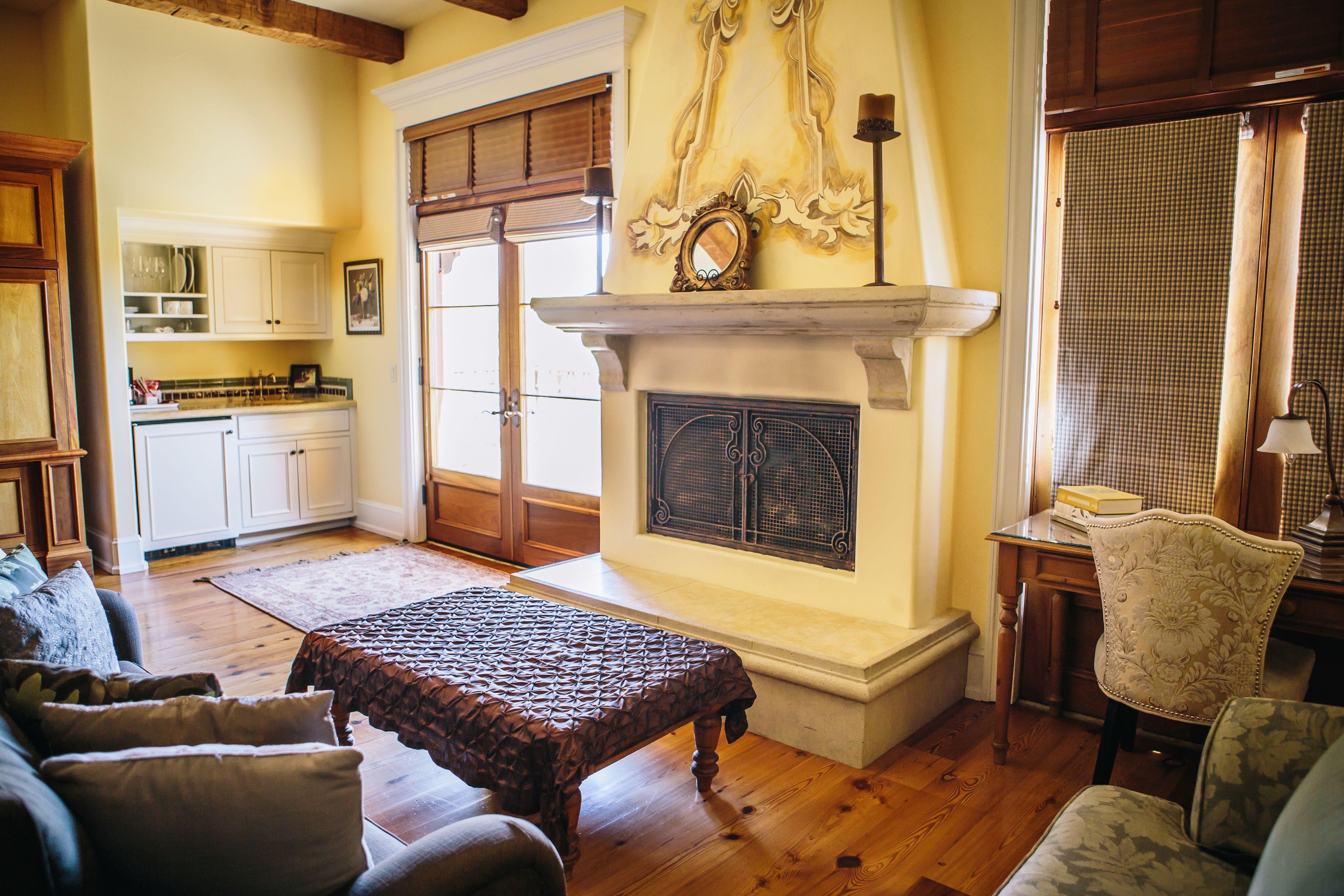 Una sala de estar con chimenea, piso de madera y un comedor con armarios y una mesa.