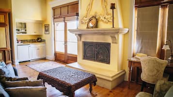 Una sala de estar con chimenea, piso de madera y un comedor con armarios y una mesa.