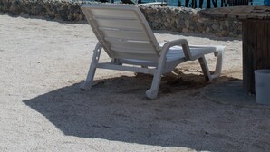 A beach chair, a lifebuoy, and a thatched structure on a pier with a view of the sea. - Apartamento Frente Islas Ballestas (Paracas)