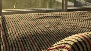 A room with a large window overlooking a grassy area and a body of water. - Apartamento Frente Islas Ballestas (Paracas)