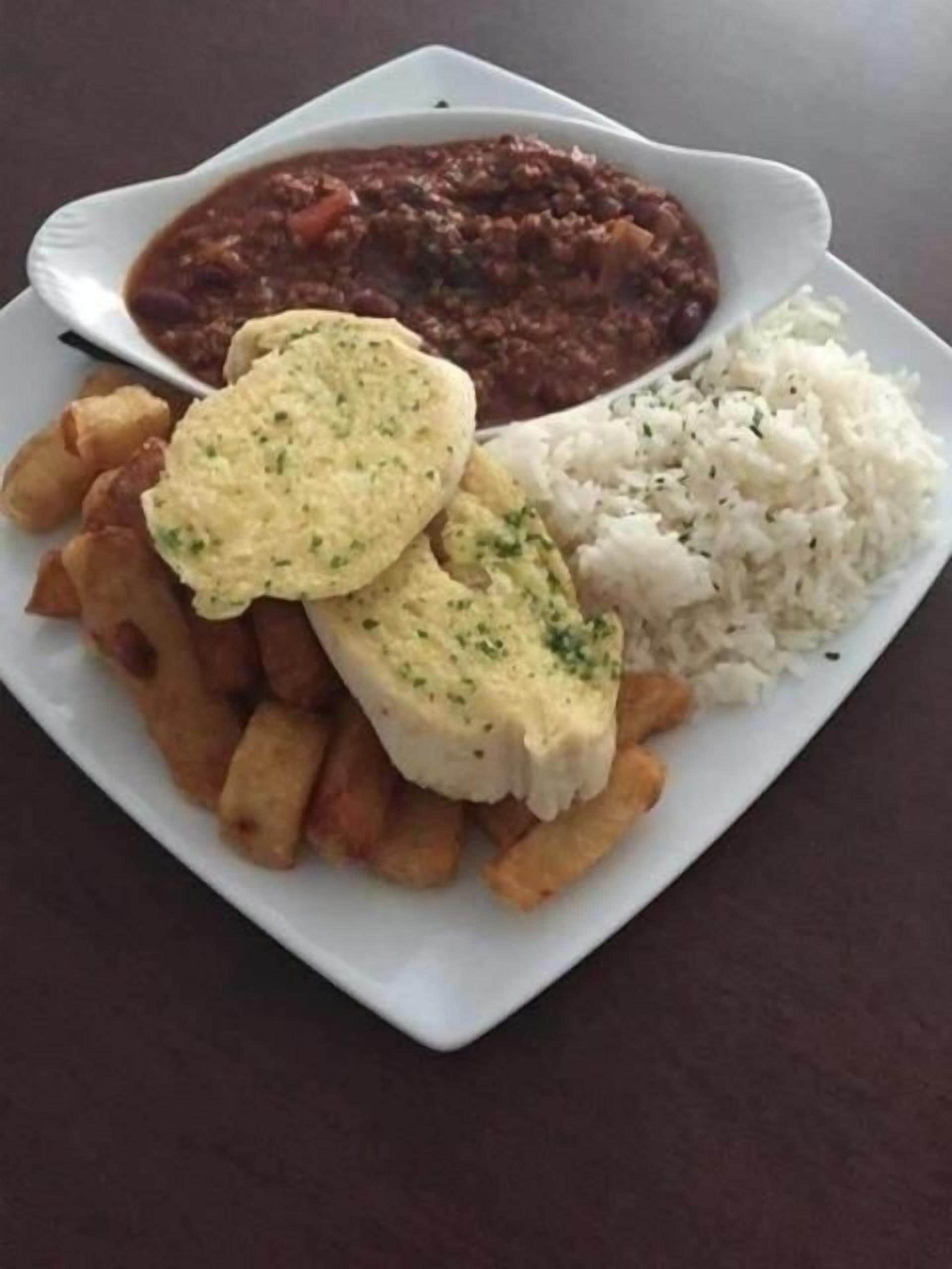 A plate of food with rice, beans, and a piece of fish.