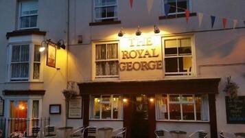A pub named 'The Royal George' with outdoor seating and a signboard.