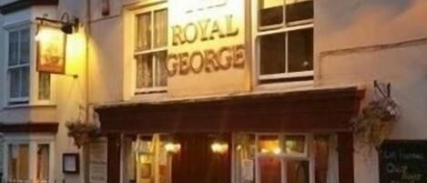 A pub named 'The Royal George' with outdoor seating and a signboard.