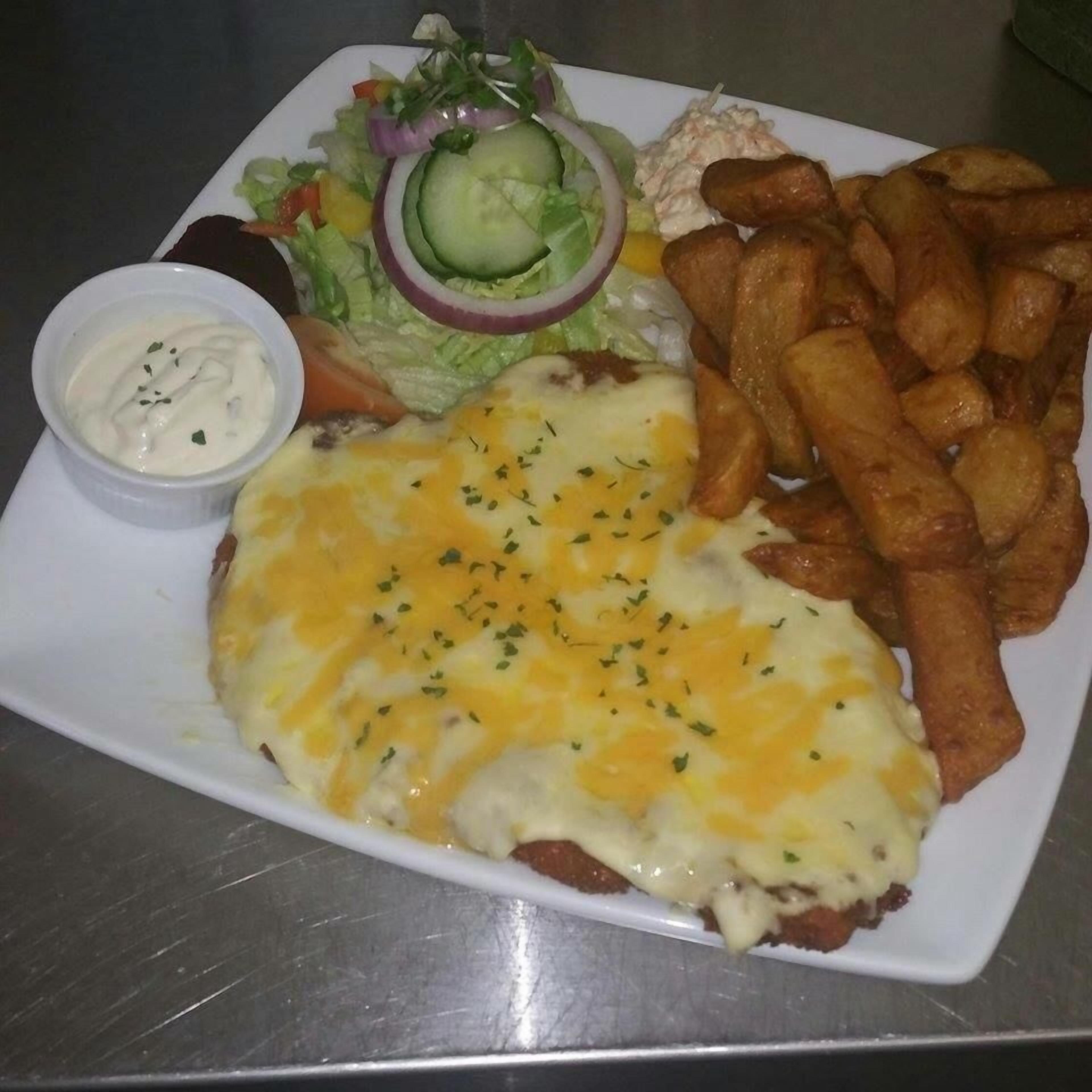 A plate with a sandwich, fries, salad, and a small bowl of sauce.