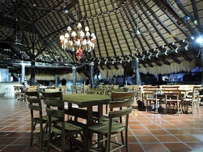 Enjoy meals in this cozy dining area with a high ceiling, wooden tables, and comfortable seating for groups.