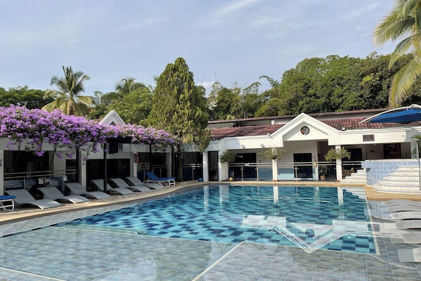 Een buitenzwembad, ligstoelen bij het zwembad