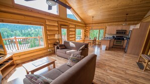 A spacious cabin with a wooden interior, a dining area, and a kitchen. - Alpine Meadows Resort (Clearwater)
