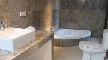 A modern bathroom with a large rectangular sink, a freestanding bathtub, and a toilet.