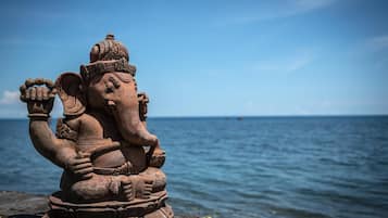 A statue of an elephant deity by the sea.