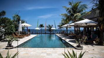 Una piscina al aire libre, sillones reclinables de piscina