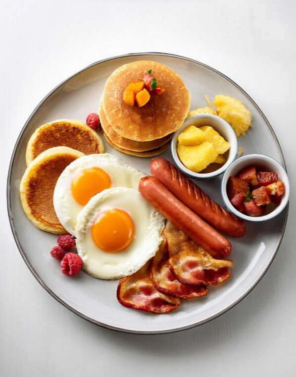 A breakfast plate with pancakes, eggs, sausages, bacon, raspberries, and fruit. - Bohol Lahoy Dive Resort (Guindulman)