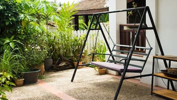 Relax in a serene outdoor space with a comfortable swing and a small table.
