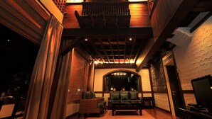 A cozy lounge area with a sofa, chairs, and a television. - Panchalae Boutique Residences (Pattaya)
