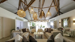 A spacious living area with high ceilings, exposed beams, and a central coffee table. - Buena Vida Resort and Spa (Daanbantayan)