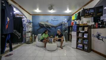 A room with a large shark mural, seating areas, and a bookshelf with books.