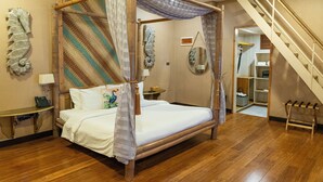 A four-poster bed with a canopy, a wooden desk with a telephone, and a staircase leading to an upper level. - Club Serena Resort (Moalboal)