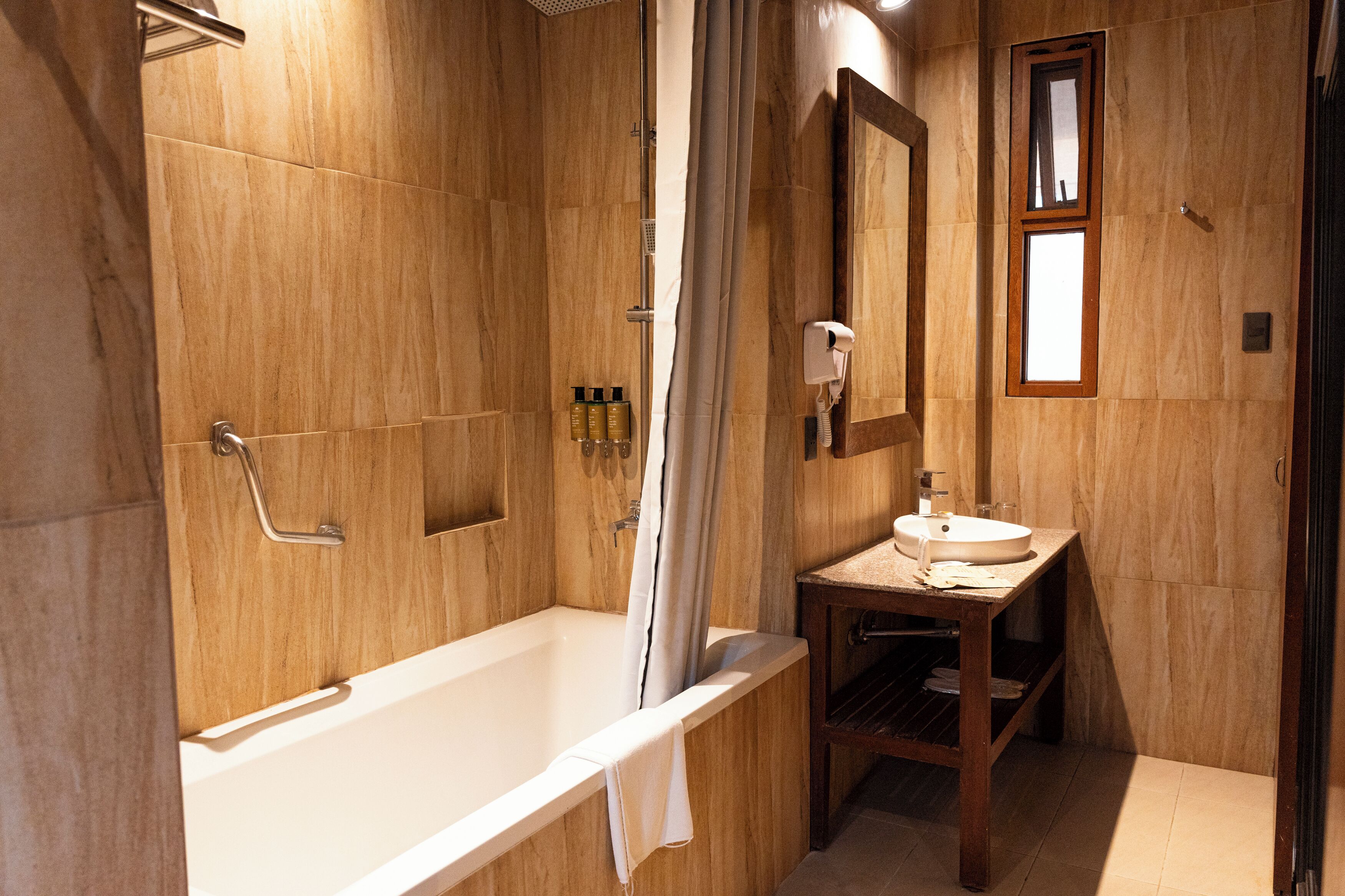 Un baño con bañera, lavabo, ducha y espejo.