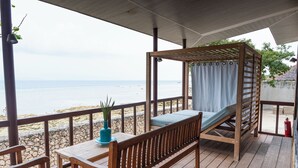 A wooden deck with a bench and table, overlooking a beach. - Club Serena Resort (Moalboal)