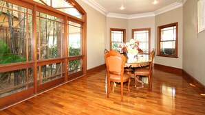 A dining area with wooden flooring, a round table, and four chairs. - Relaxin (Middle Dural)
