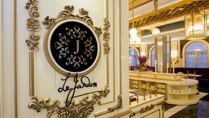 A luxurious interior with ornate gold detailing, a central circular sign with a 'J' and 'Le Jardin' text, and a well-lit dining area with a marble floor. - Park View Hotel (Bandung)