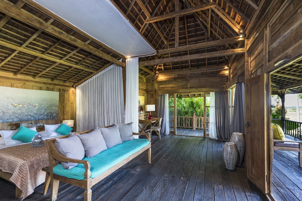 A wooden interior with a sofa, bed, and dining area.