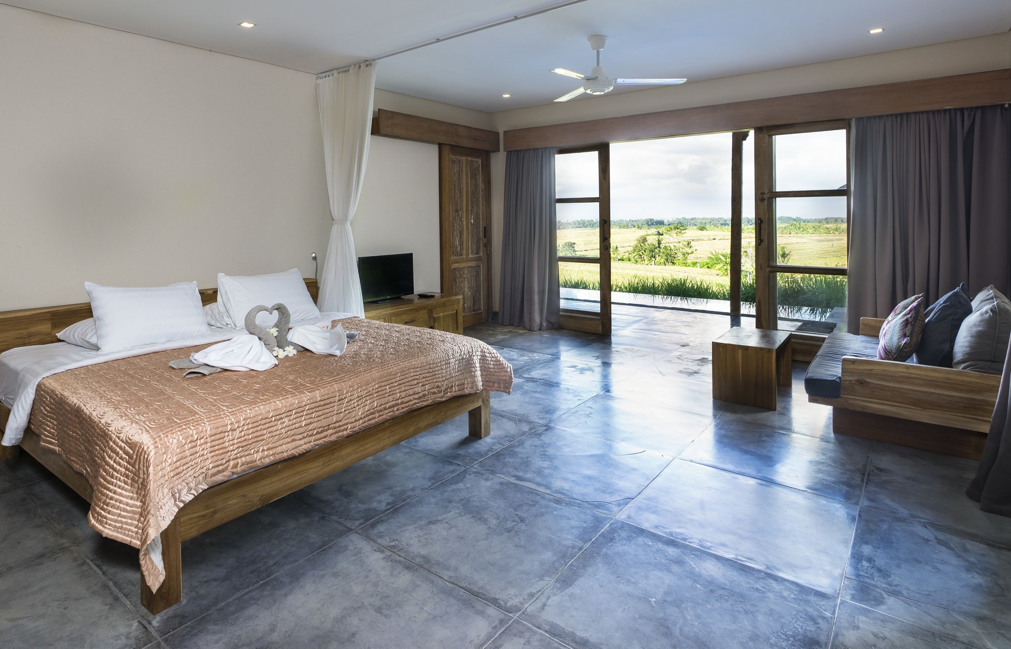 Un dormitorio amplio con una cama grande, un banco de madera y un sofá.