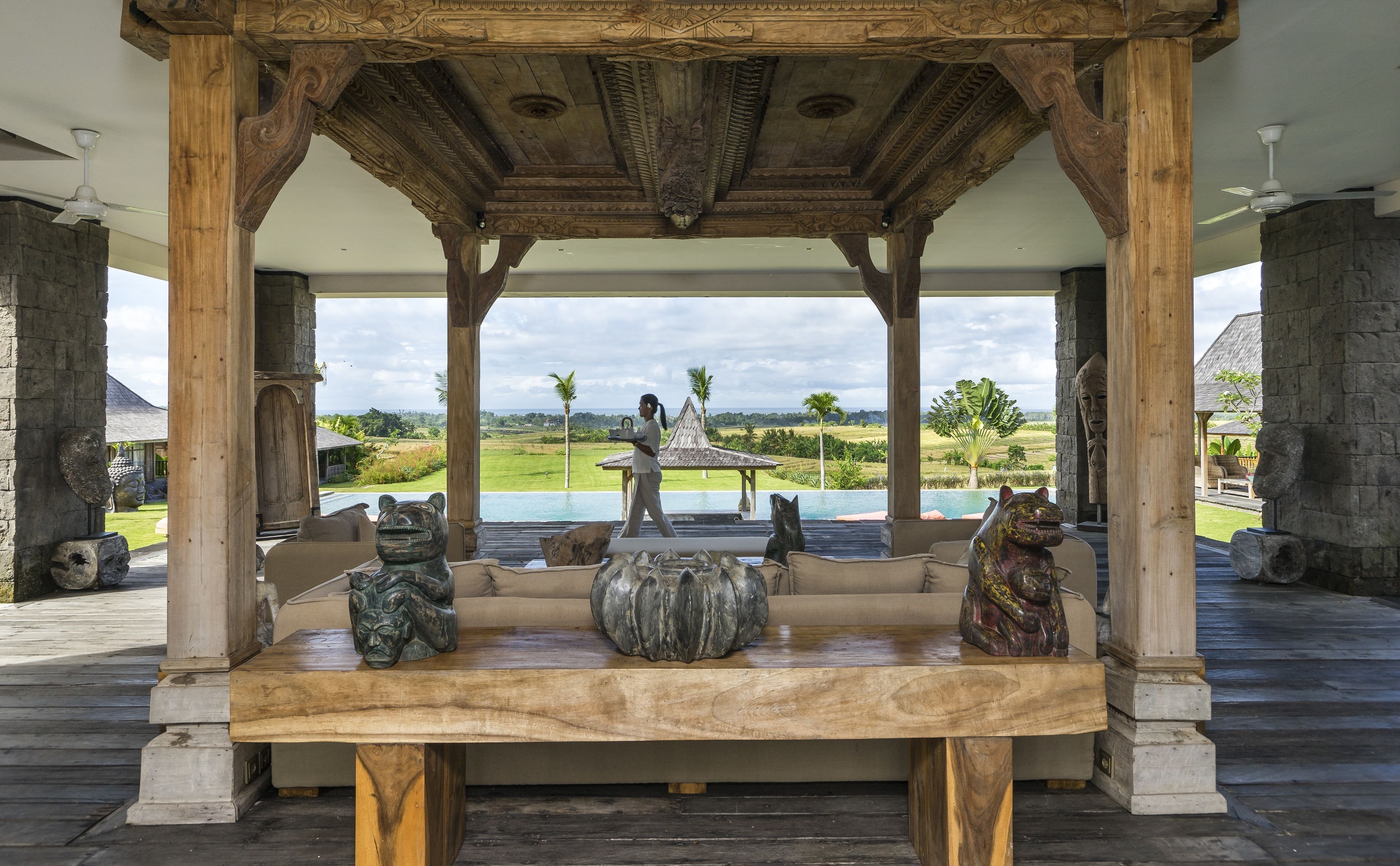 A wooden gazebo with a view of a golf course and a pool.