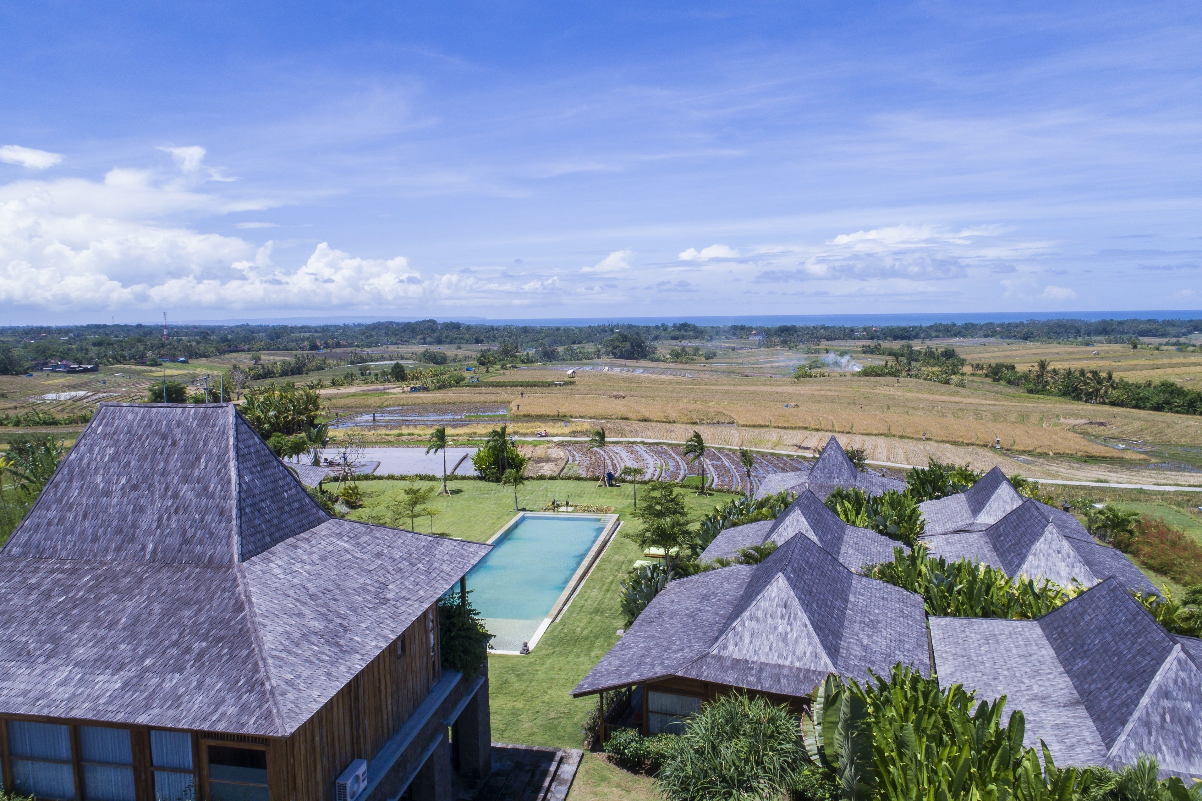 Un resort con varias construcciones, piscina y amplias vistas del paisaje circundante.