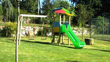 Ein Spielplatz mit Rutsche und Schaukeln.